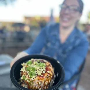 a woman holding a bowl of food
