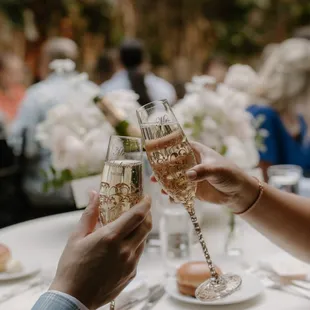 two people clinking glasses of champagne