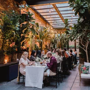 a group of people sitting at a table in an outdoor restaurant