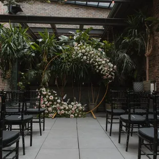 an outdoor wedding ceremony with black chairs