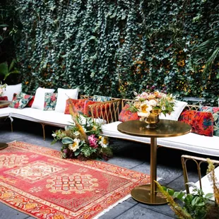 a seating area with white couches and colorful pillows