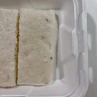 two slices of cheese in a styrofoam container