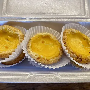 three pastries in a styrofoam container