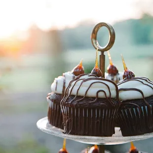 chocolate cupcakes with white frosting and drizzles