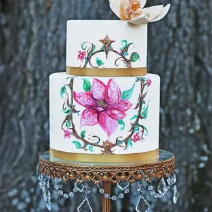 a three tiered cake with a flower on top