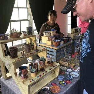 a man and a woman looking at a display of pottery