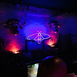 a man sitting in front of a neon sign