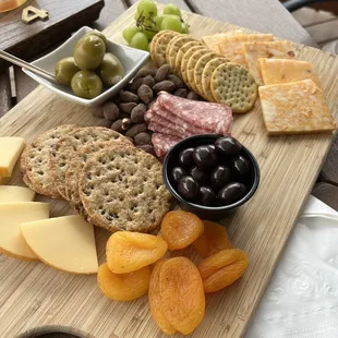 a platter of cheese, olives, and crackers