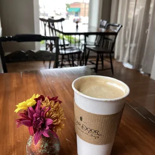 a cup of coffee and a vase of flowers