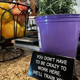 a pot of lemons and a sign that says you don't have to be crazy to work here we'll