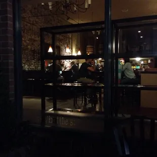 people sitting at tables in a dimly lit restaurant