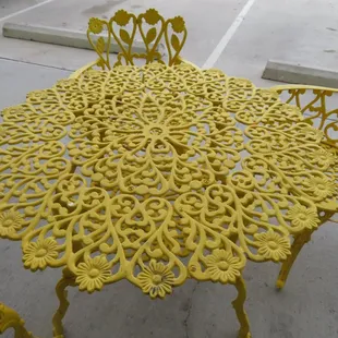 a yellow table and chairs in a parking lot