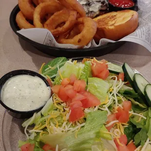 Mushroom and swiss burger with onion rings and side salad