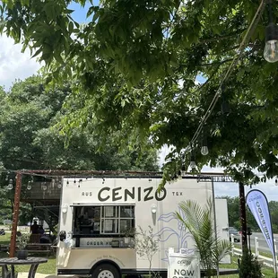 a food truck parked under a tree