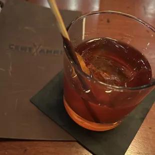 a drink in a glass with a wooden spoon