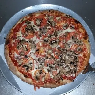 a pizza with mushrooms and tomatoes