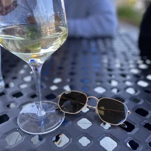 a glass of wine and a pair of sunglasses