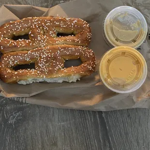 a pretzel and two cups of mustard