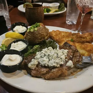 Surf and turf ribeye with Bleu cheese, calamari steak, loaded baked potato