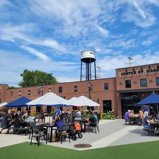 people sitting at tables under umbrellas