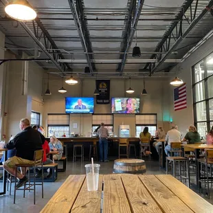 people sitting at tables and watching televisions