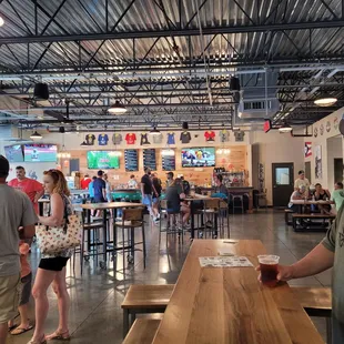 a man standing at a table with a beer in his hand
