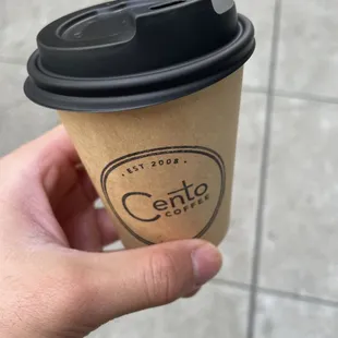 a hand holding a coffee cup
