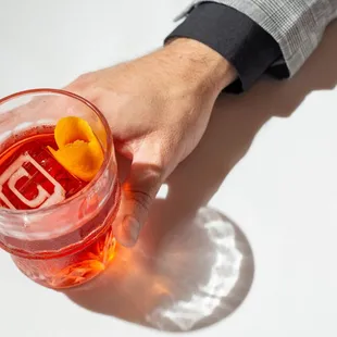 a person holding a glass of orange juice