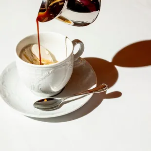 a coffee being poured into a cup
