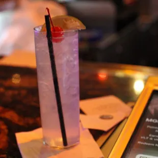 a purple drink with a slice of lime