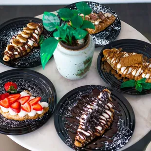 Croissant waffles with cream and toppings (strawberries and cream, cookies and cream, Biscoff cookie butter, s'mores, and banana Nutella)