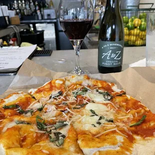 a pizza and a glass of wine