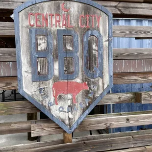 a weathered sign on a wooden bench