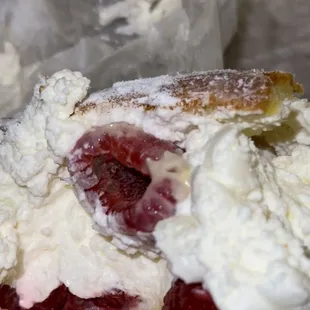a close up of a pastry with whipped cream and berries