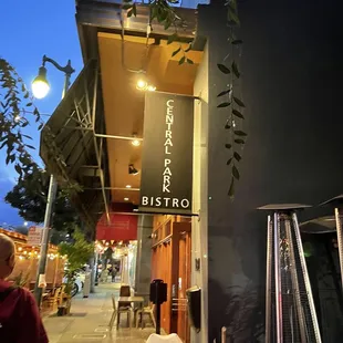 a man sitting at a table outside a restaurant
