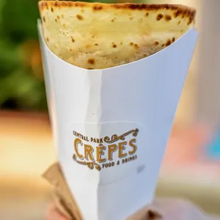 a hand holding a crepe cone
