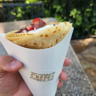 a hand holding a crepe