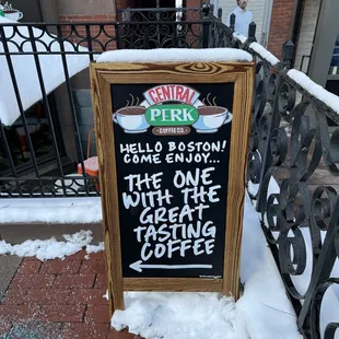 a chalkboard sign in the snow