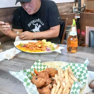 a man sitting at a table with plates of food