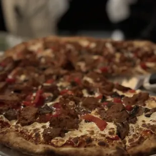 a pizza on a silver platter on a table