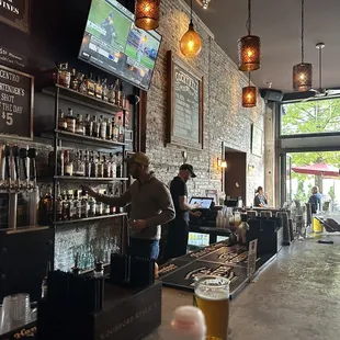 a man standing at a bar with a glass of beer