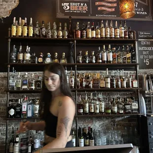 a woman behind the bar at a bar