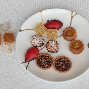 Petit-fours: Toasty coconut macaroons, pineapple yuzu cardamom pate de fruits, caramel chocolate tart, fruit tart, chocolate, and caramels