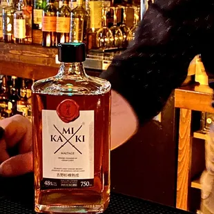 a person pouring a drink at a bar