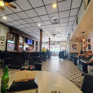 Wide angle of the interior: bar, booths and mosaic tile floor