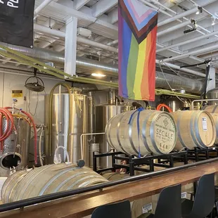 a row of barrels with a rainbow flag in the background