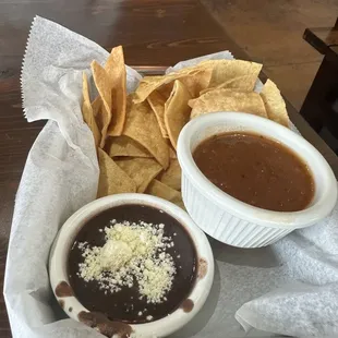 a bowl of black beans and a bowl of tortillas