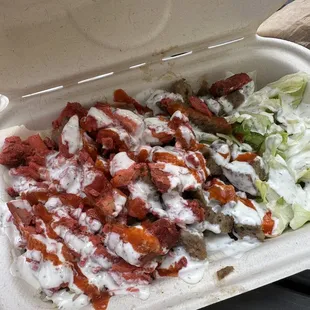 a styrofoam container filled with meat and vegetables