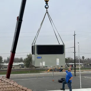 Crane lift for multiple unit replacements at a commercial building.