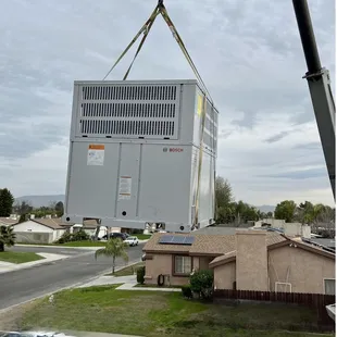 Crane lift new Heat-pump roof top unit set with new roof curb.